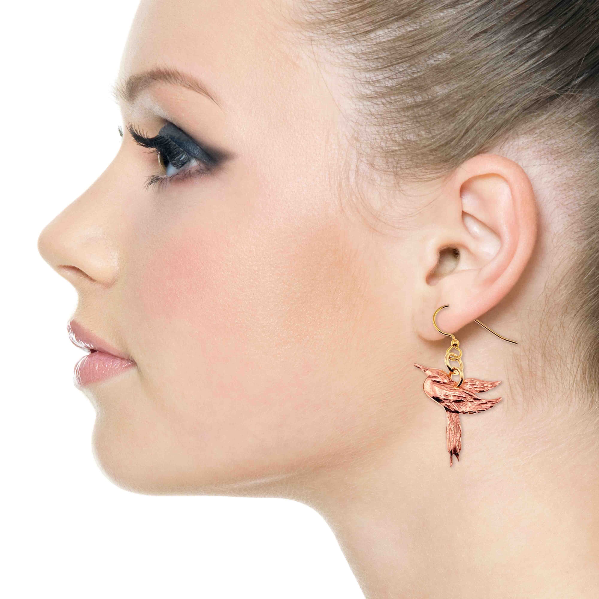 Close-up of a woman wearing a Great Blue Heron Copper Dangle Earring