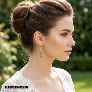 2 of 7: Side view of an AI generated female model wearing a hammered copper raindrop earring with her brown hair styled in an updo. The narrow polished copper drop hangs below a brass French ear wire and stands out against her neck. A softly blurred green outdoor setting creates a bright spring look.