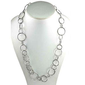 6 of 8: Hammered stainless steel chain link necklace displayed on a white jewelry bust against a white background. The 26 inch necklace features mixed round link sizes that create a flowing pattern, with polished silver tone surfaces showing the handmade hammered texture.
