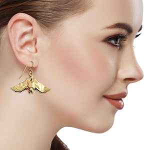 4 of 7: Close-up of a woman wearing Hanging Bat Nu Gold Brass Dangle Earrings on a white background