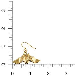 5 of 7: Gold bat-shaped earring on a ruler for scale