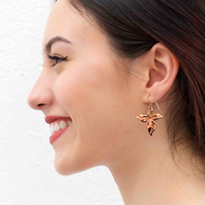 2 of 7: A Smiling Woman Wearing Ivy Leaf Copper Earrings
