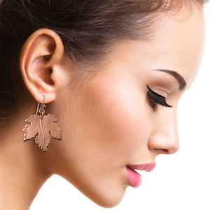 6 of 7: Close-up of a woman wearing Large Maple Leaf Copper Dangle Earrings  with a plain background