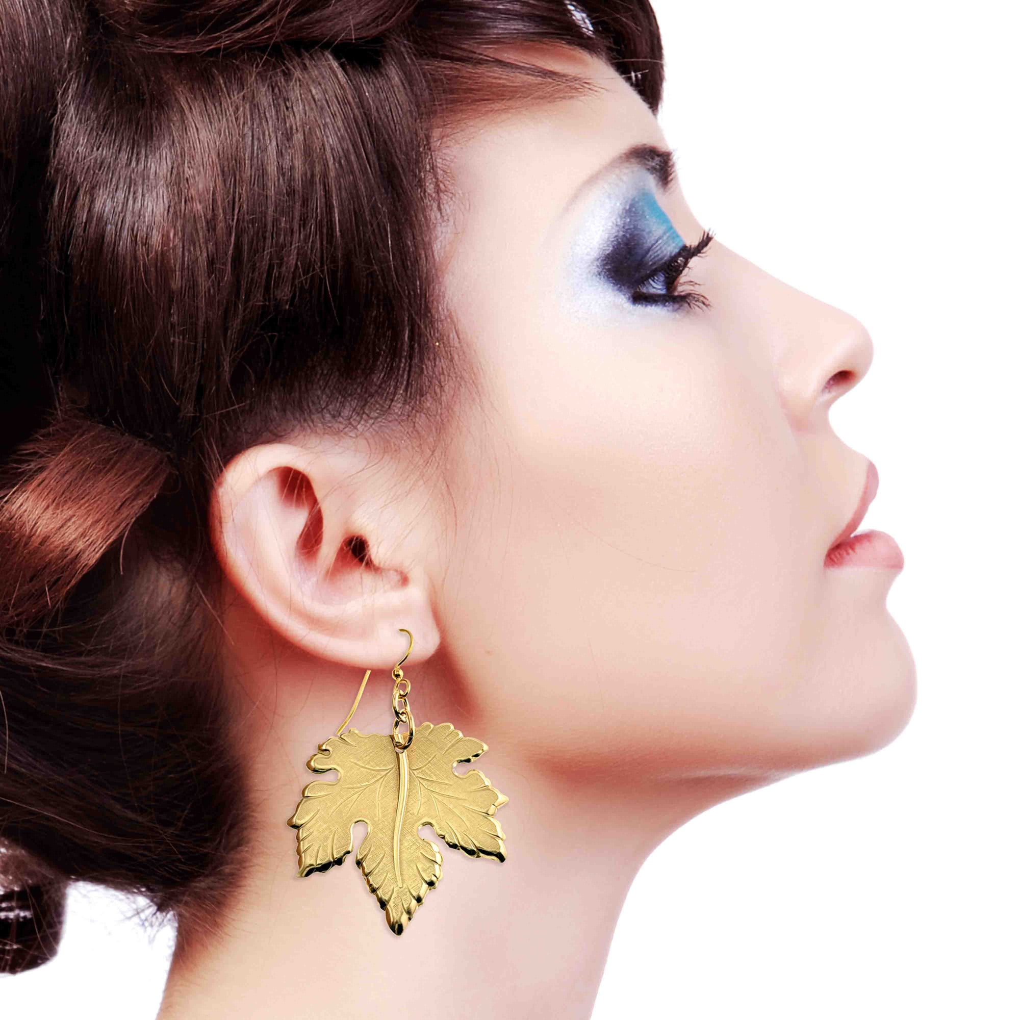 Large Maple Leaf Nu Gold Brass Dangle Earring worn by a model on a white background