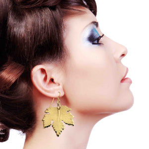 7 of 7: Large Maple Leaf Nu Gold Brass Dangle Earring worn by a model on a white background