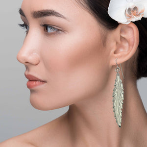 4 of 7: Stunning Woman Wearing Long Feather Aluminum Drop Earrings 