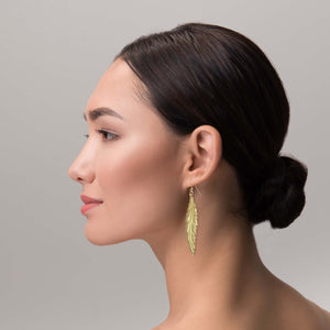 4 of 7: Elegant Woman Wearing Long Feather Brass Nu Gold Drop Earrings