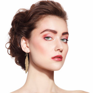 2 of 7: Stylish Woman Wearing Long Feather Bronze Drop Earrings