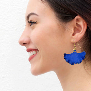 6 of 7: A Smiling Woman Wearing Medium Cobalt Blue Anodized Aluminum Ginkgo Leaf Earrings