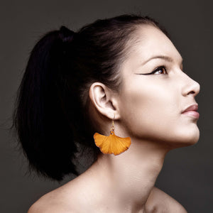 6 of 9: Elegant lady showcasing black hair and statement orange ginkgo leaf earrings