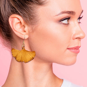 2 of 9: A woman wearing Orange Anodized Aluminum Ginkgo Leaf Drop Earrings, , adding a touch of elegance to her outfit