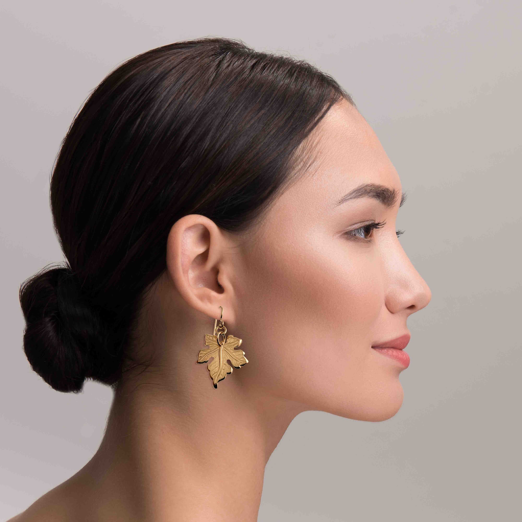 Woman wearing Medium Maple Leaf Bronze Dangle Earrings with a neutral background