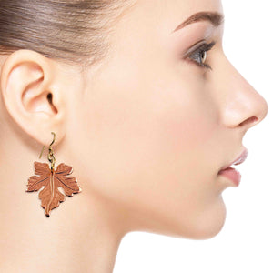 4 of 7: Close-up of a woman wearing Medium Maple Leaf Copper Dangle Earrings on a white background