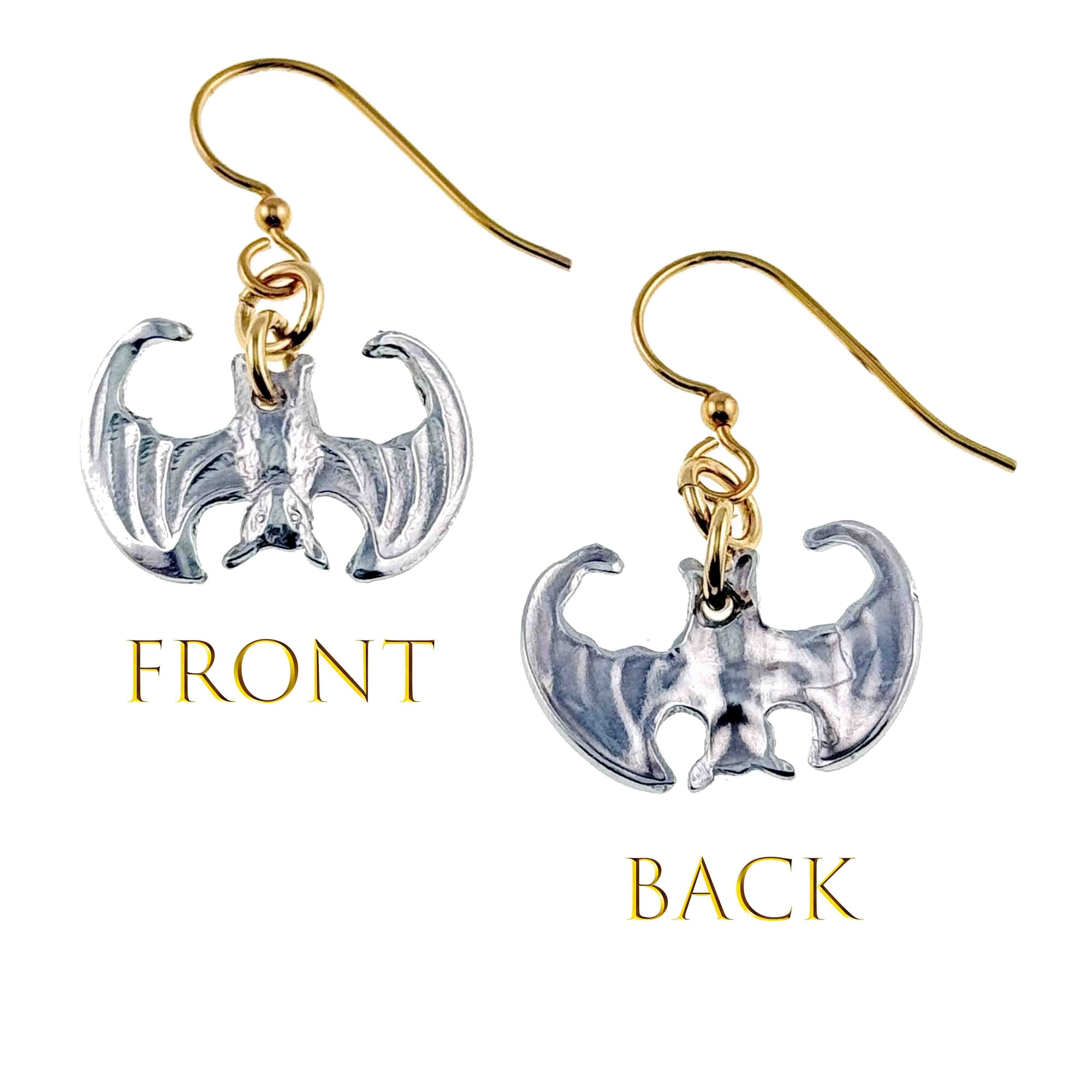 Bat-shaped earrings with gold and silver finishes on a white background.