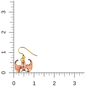 5 of 7: Image of a single handcrafted copper vampire bat dangle earring with brass French ear wire placed against a ruler grid background, showing the earring measures approximately 1 1/4 inches in length and 1 inch in width.