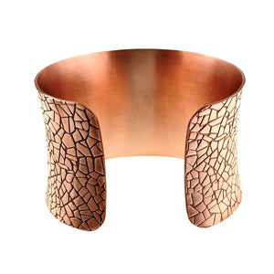 7 of 9: Rear product view of the wide solid copper cuff bracelet on a white background. The open ends reveal the smooth brushed interior and rounded edges. Embossed mosaic texture covers the outside of both ends, while the anticlastic form narrows slightly through the center.