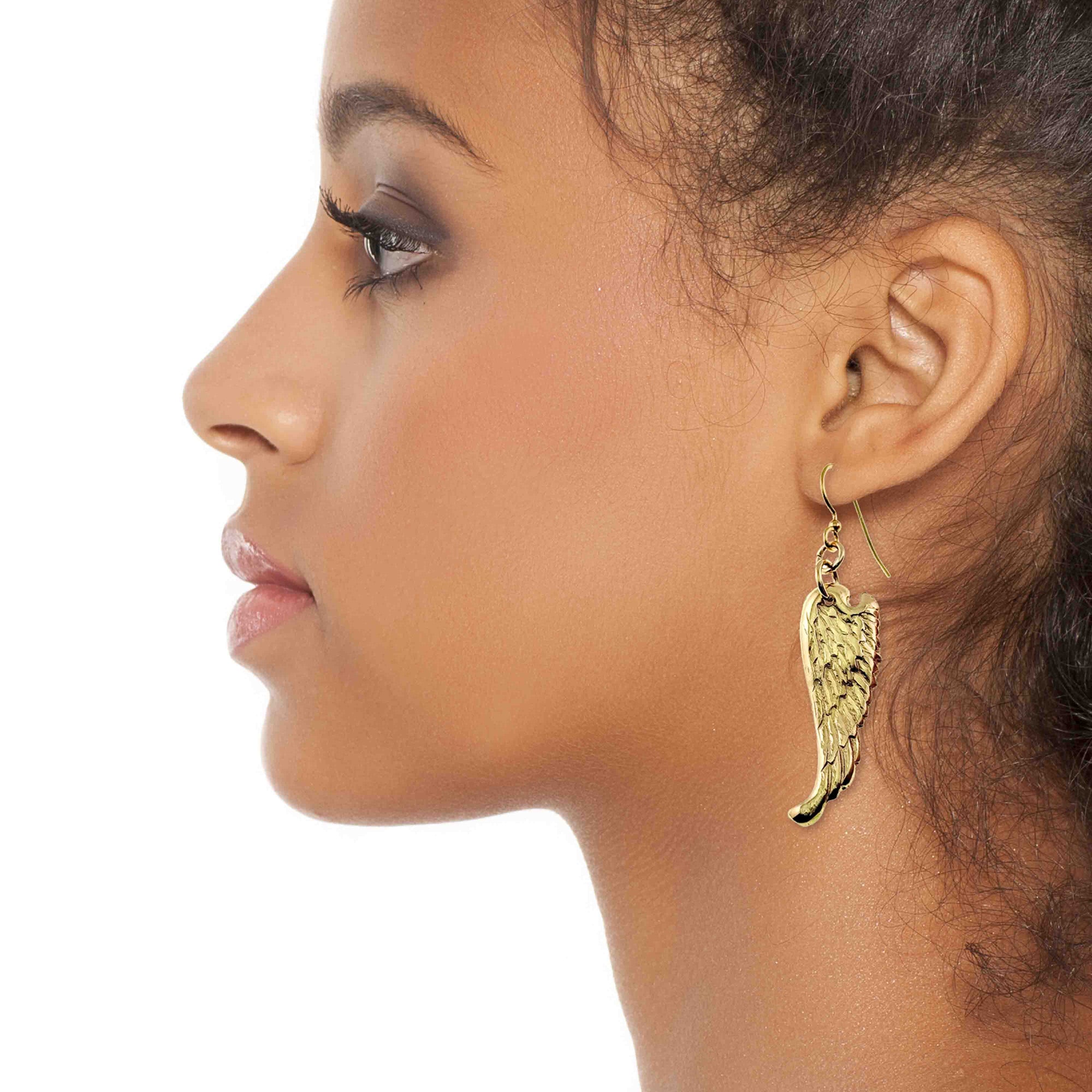 Close-up of a woman wearing Nu Gold Brass Guardian Angel Wing Drop Earrings  on a white background