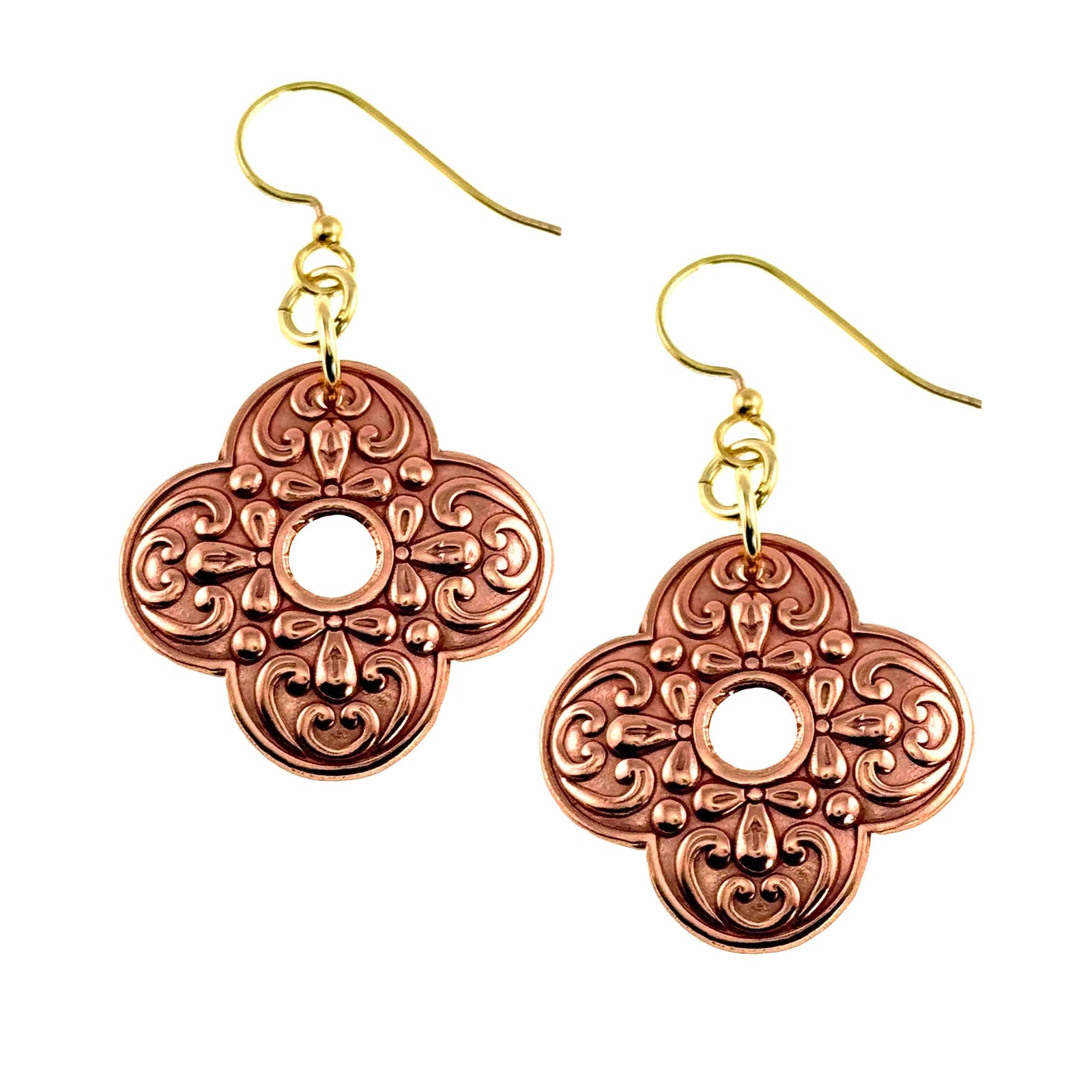 Ornate clover-shaped copper drop earrings with polished scrollwork detailing and a small center cutout. Warm raw copper finish paired with gold tone brass French ear wires, shown on a clean white background.
