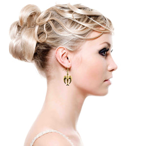 6 of 7: Woman with an elegant updo wearing a handcrafted Nu Gold brass peace dove dangle earring, featuring a detailed bird design, shown against a white background.