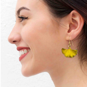 2 of 7: A Smiling Woman Wearing Small Canary Yellow Anodized Aluminum Ginkgo Leaf Earrings