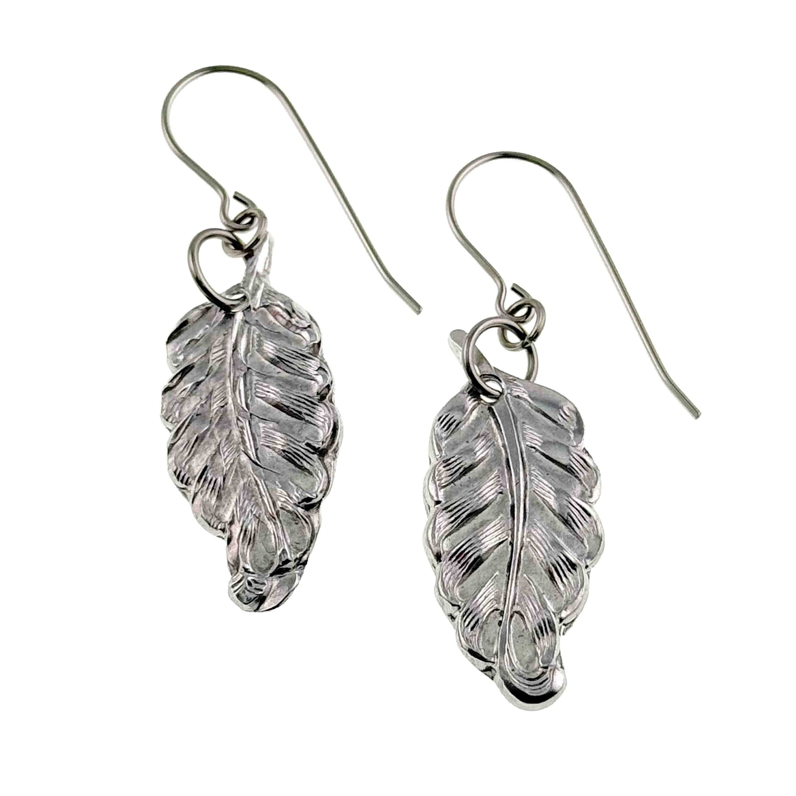 A pair of small aluminum dangle earrings shaped like soft feathers, each with detailed die struck lines that create a textured, natural look. The feathers hang from simple stainless steel French ear wires that curve gently at the top. The earrings appear lightweight with a bright silver tone and a smooth reflective finish.
