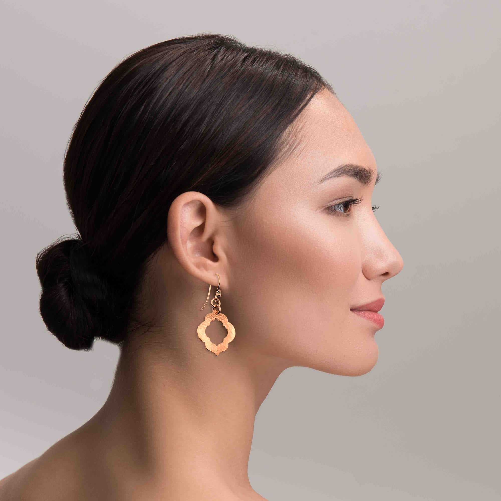 An Elegant Woman Wearing Small Hammered Copper Pierced Quatrefoil Dangle Earrings