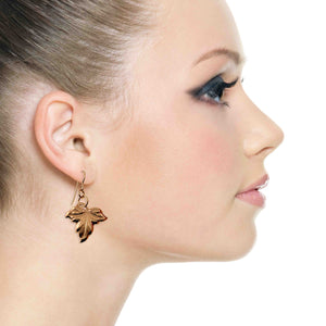 2 of 7: Close-up of a woman wearing a Small Maple Leaf Bronze Dangle Earring on a white background