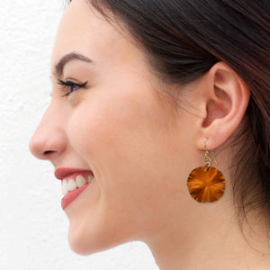 6 of 7: Woman wearing orange lily pad earrings with gold hooks.