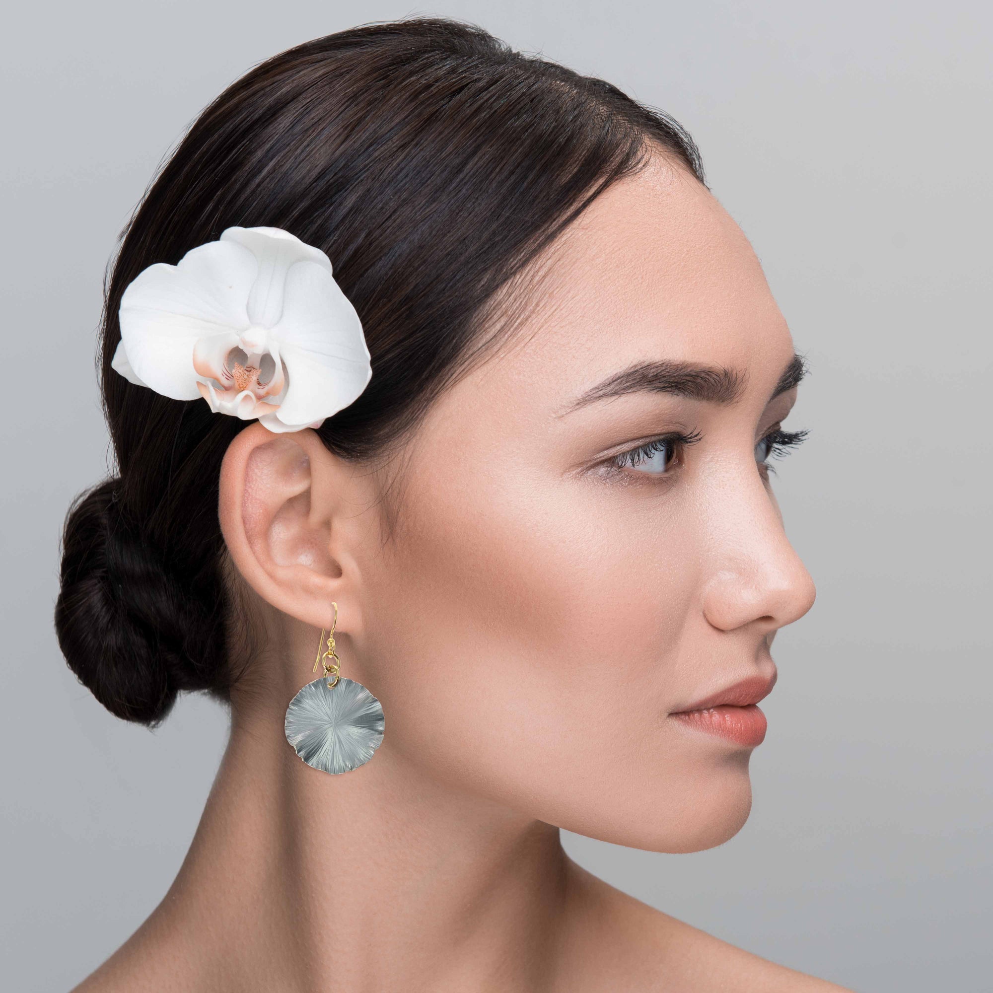 An Elegant Woman Wearing a Pair of Small Pewter Gray Anodized Lily Pad Leaf Drop Earrings