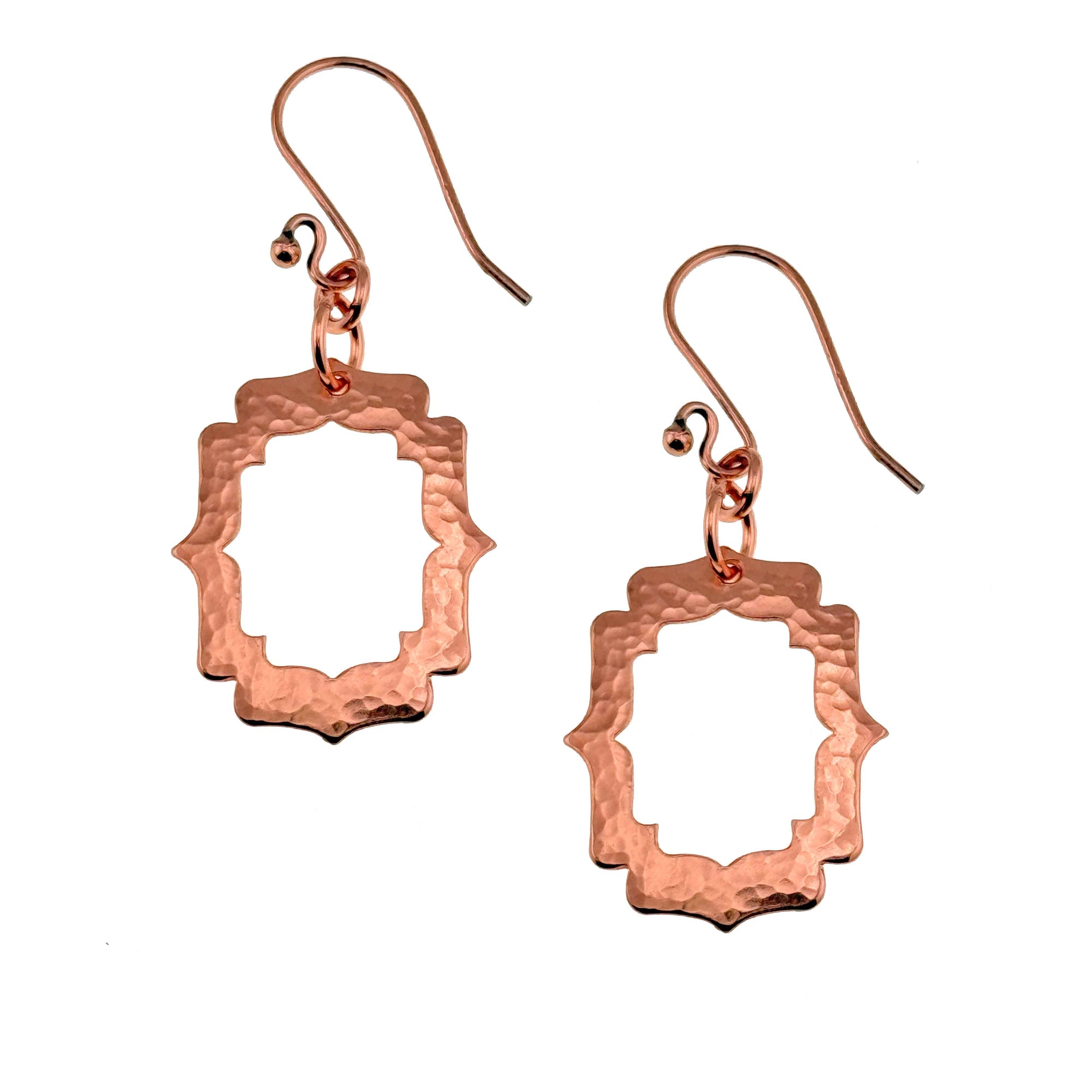 A Pair of Small Pierced Hammered Copper Arabesque Shield Earrings on a White Background