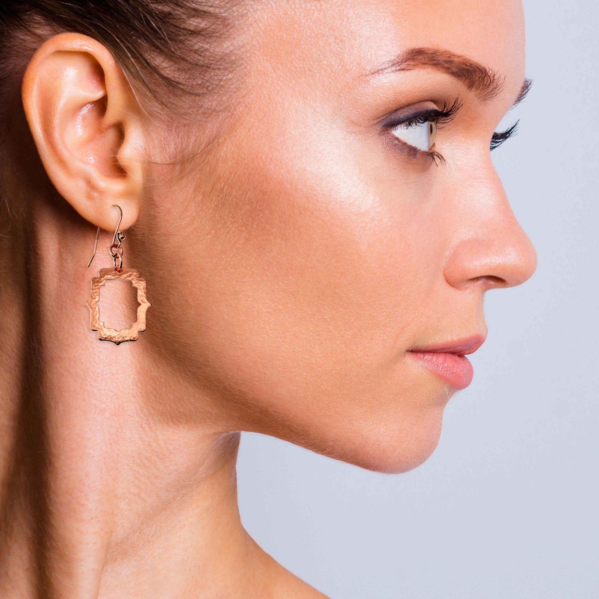 A Fashionable Woman Wearing Small Pierced Hammered Copper Arabesque Shield Earrings
