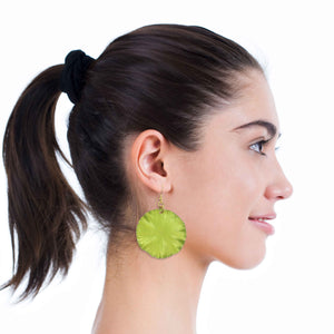2 of 7: A Chic Woman Wearing Sour Candy Apple Anodized Aluminum Large Lily Pad Earrings