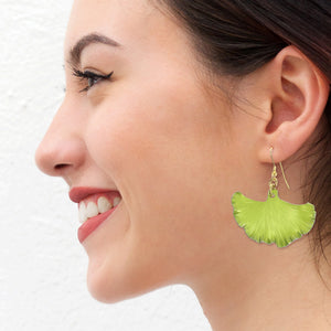 6 of 7: A Chic Woman Wearing Medium Sour Candy Apple Anodized Aluminum Ginkgo Leaf Earrings