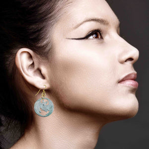 2 of 8: Model wearing Vampire Bat Aluminum Disc Earrings in side profile close up. Handmade brushed aluminum disc earrings feature a flying vampire bat cutout suspended from gold tone French ear wires. Lightweight gothic style earrings hang just below the earlobe against dark hair and dramatic winged eyeliner.