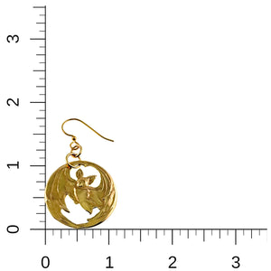 4 of 7: Gold-tone brass disc earring with a die-struck bat design shown next to a ruler for scale. The bat features outstretched wings with cutout areas inside a round frame. The earring hangs from a brass French hook with small connecting rings. The image highlights its approximate size of 1 3/4 inches in length and 1 inch in width.