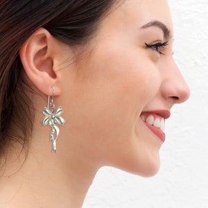 6 of 8: Woman Wearing Yuletide Ribbon Aluminum Dangle Earrings