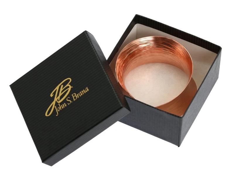 Anticlastic Copper Bark Bangle Bracelet inside of a Black Gift Box with Gold Logo