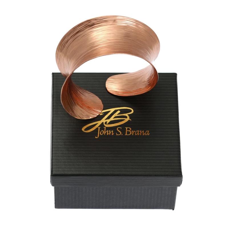 Anticlastic Copper Bark Bangle Bracelet on top of a Branded Black Gift Box