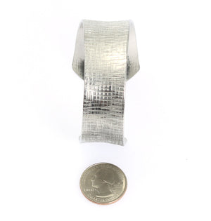 5 of 7: Width of Anticlastic Tapered Linen Aluminum Bangle Bracelet compared to a US Quarter Coin