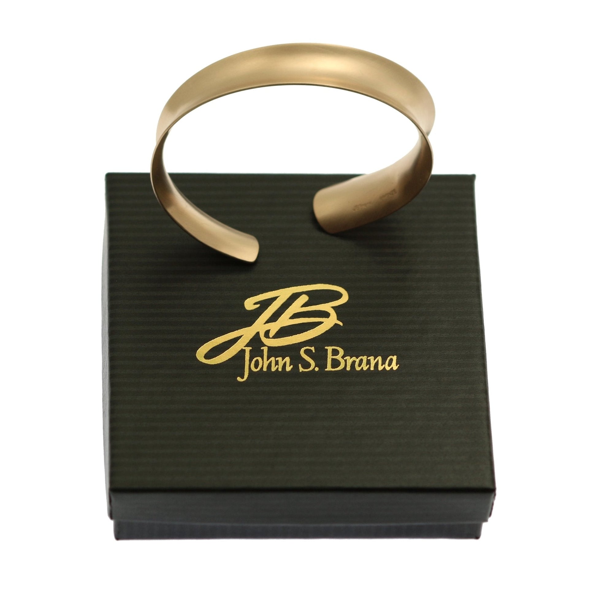 Brushed Bronze Anticlastic Bangle Bracelet on top of a Black Gift Box