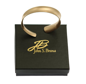 5 of 7: Brushed Bronze Anticlastic Bangle Bracelet on top of a Black Gift Box