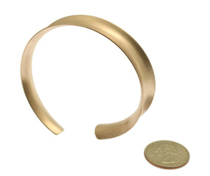 3 of 7: Width of Brushed Bronze Anticlastic Bangle Bracelet compared to a US Quarter Coin