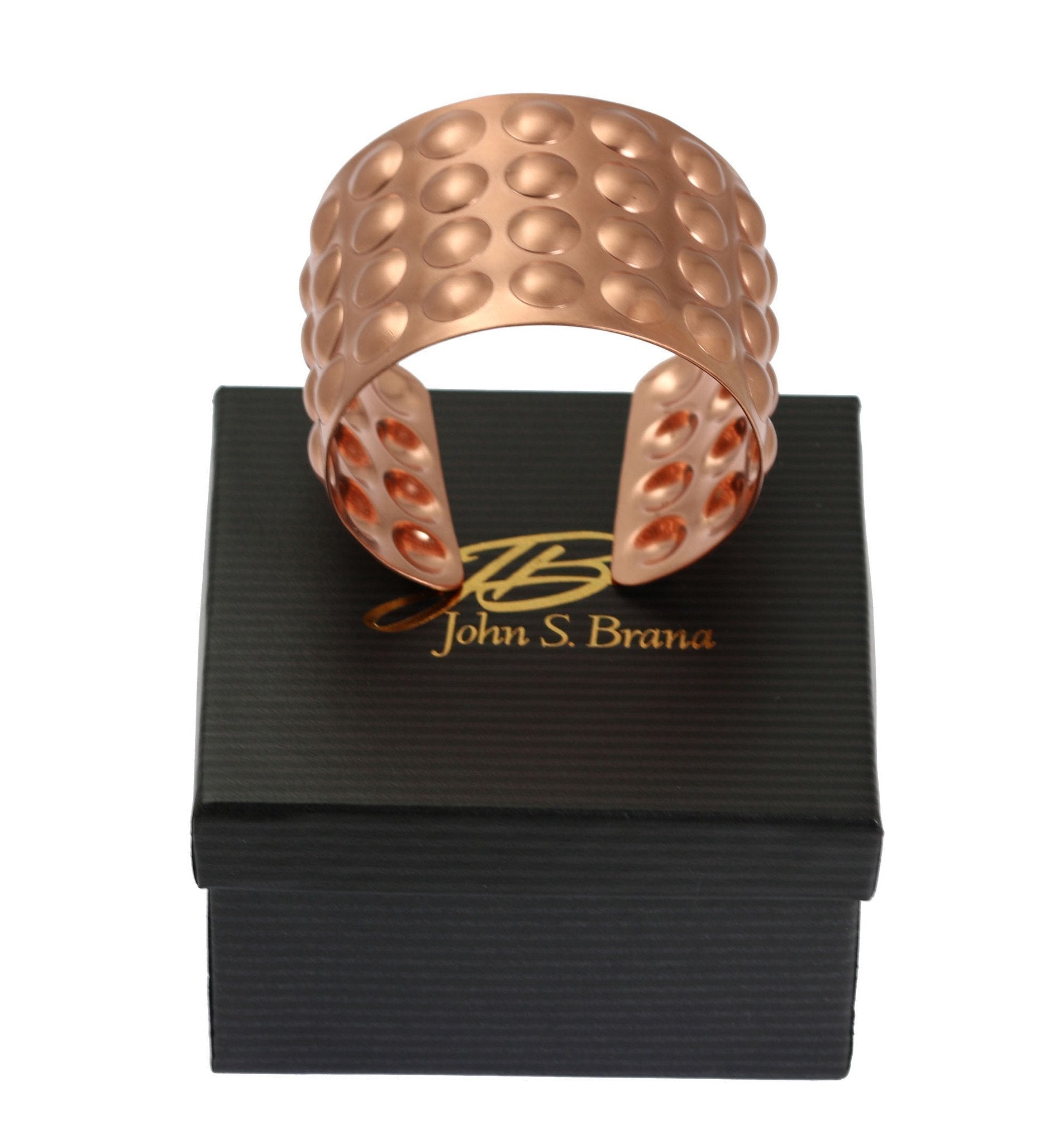 Brushed Copper Bubble Wrap Cuff Bracelet on top of a Black Gift Box with Gold Logo