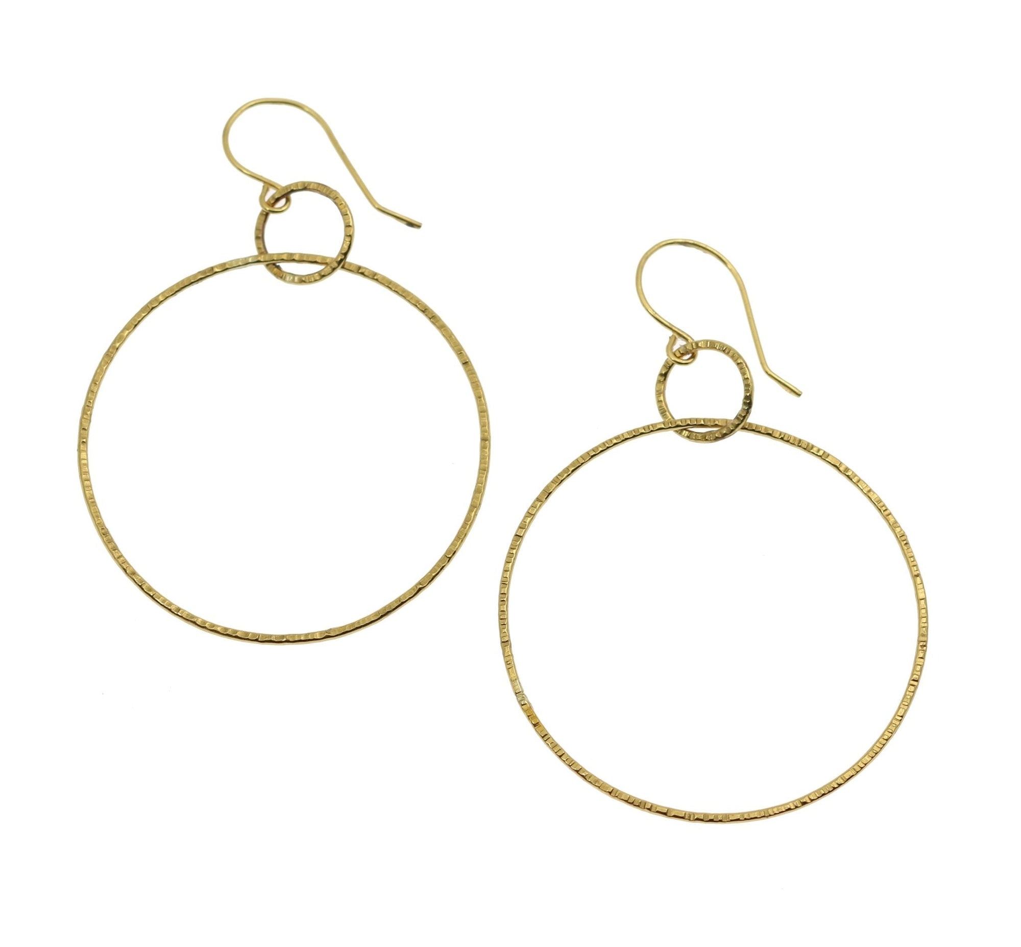 A Pair of Chased Nu Gold Brass Hoop Earrings on a White Background