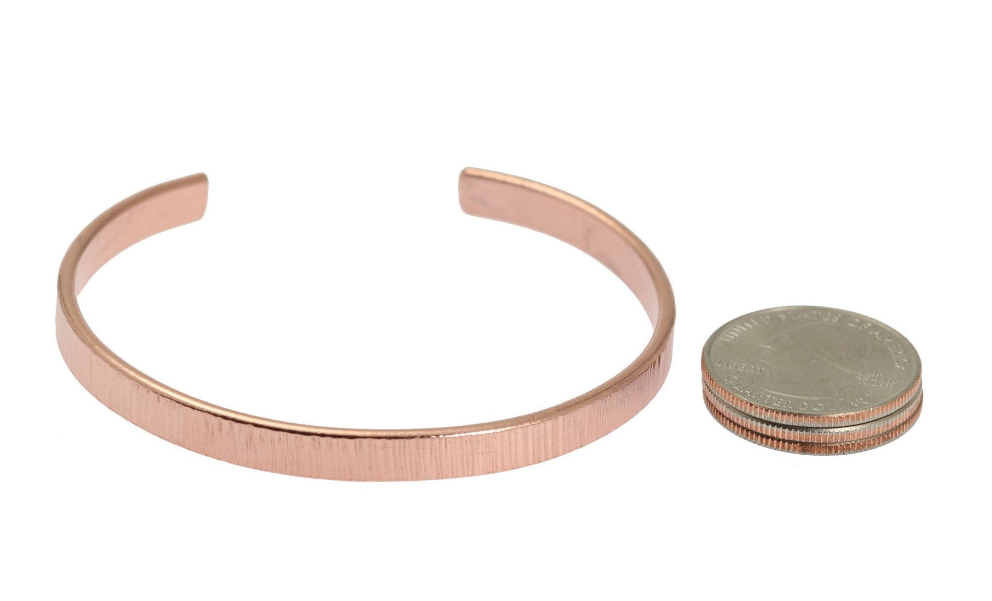 Width of Men's Thin Chased Copper Cuff Bracelet compared to a stack of 3 US Quarter Coins