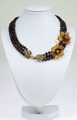 1 of 3: A Faceted Garnets And Citrine Flower Necklace on a White Neck Display