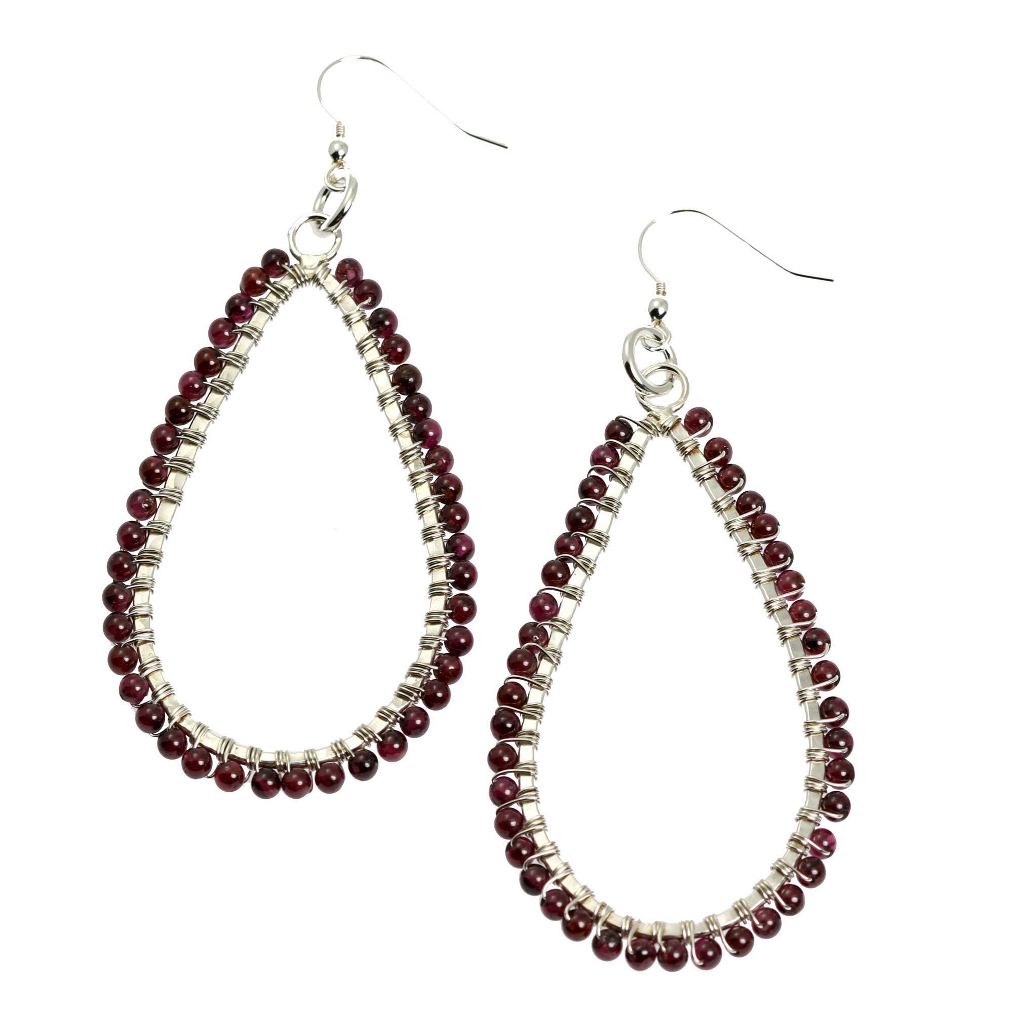 A Pair of Hammered Fine Silver Garnet Teardrop Earrings on a White Background