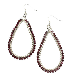 1 of 3: A Pair of Hammered Fine Silver Garnet Teardrop Earrings on a White Background