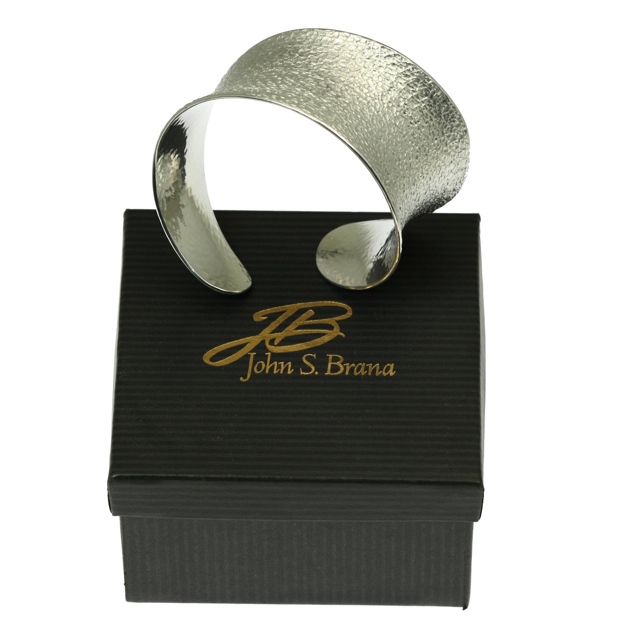 Texturized Aluminum Anticlastic Bangle on Top of a Black Gift Box
