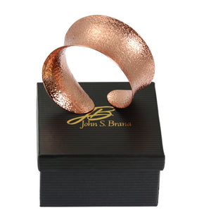 6 of 7: Texturized Anticlastic Copper Bangle Bracelet on Top of a Black Gift Box